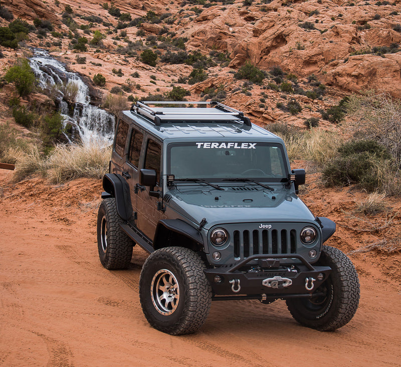 Gray Jeep Wrangler JK Unlimited with a TeraFlex Nebo roof rack and raised rail kit in red rock desert