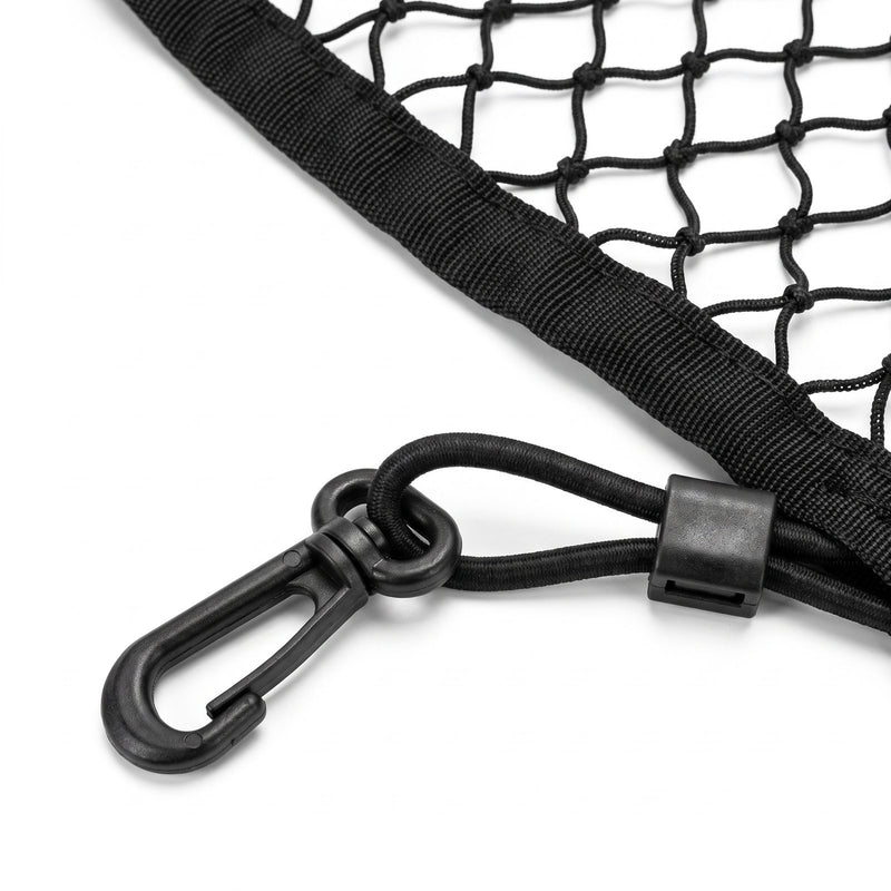 Close-up of one corner of the black cargo net: a black plastic snap hook with a swivel eye, the elastic cord looped once through the eye and held by a small plastic clamp, next to the woven end sleeve and knotted mesh