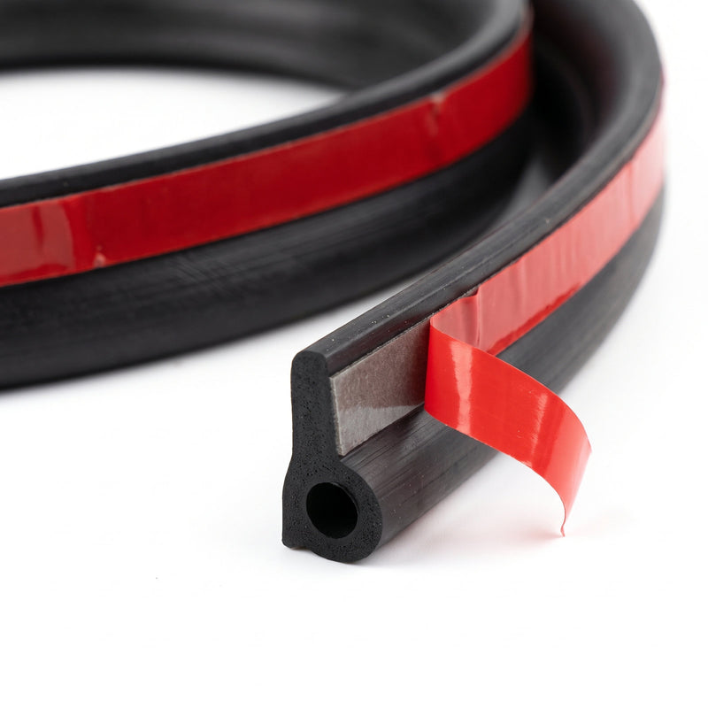 Close-up of the tailgate seal's cut end showing the hollow rubber bulb and the red liner peeled back from the adhesive base
