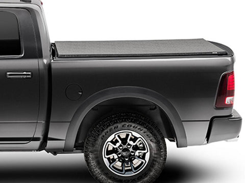 Black soft folding tonneau cover closed flat over a pickup bed, side profile on a white background