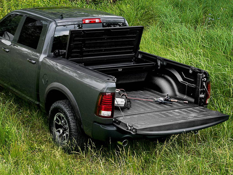 Front section of the cover tilted up and tailgate lowered, bed fully open outdoors