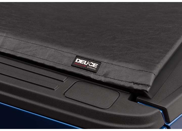 Close-up of the DEUCE name plate where the folded cover meets the side rail on a TruXedo Deuce soft folding tonneau cover
