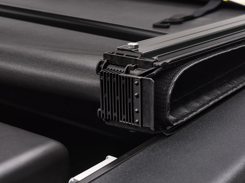 Close-up of the folded panel stack resting on the side rail, its latch block in view on a TruXedo Deuce soft folding tonneau cover
