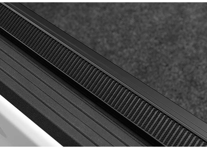 Close-up of the hook-and-loop strip along the top of the side rail, in tight macro on a TruXedo Lo Pro soft roll-up tonneau cover