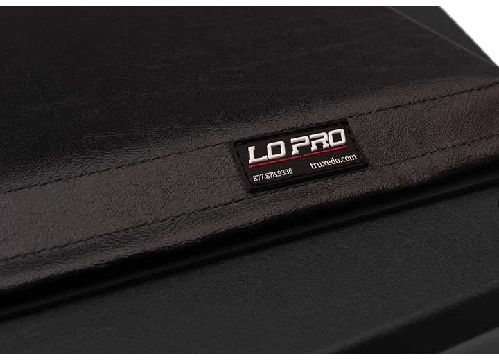 Close-up of the LO PRO name plate on the flat cover surface, its truxedo.com line legible on a TruXedo Lo Pro soft roll-up tonneau cover
