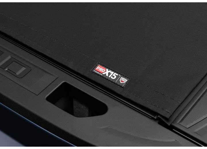 Close-up of the PRO X15 name plate beside a deep scalloped tailgate handle recess on a TruXedo Pro X15 soft roll-up tonneau cover