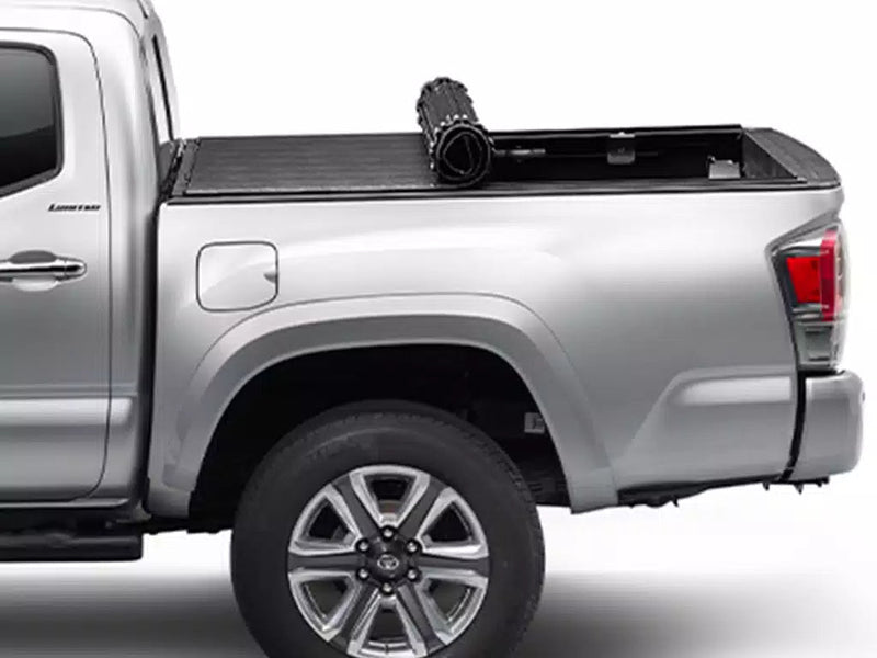 Sentry tonneau cover partly rolled up toward the cab on a silver pickup, side view