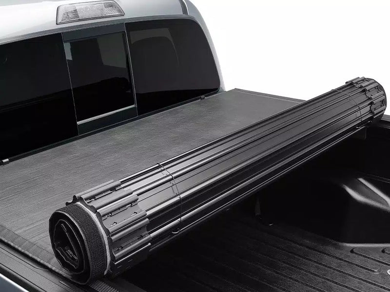 Close-up of the rolled Sentry cover sitting against the cab, showing its aluminum slats and black vinyl top
