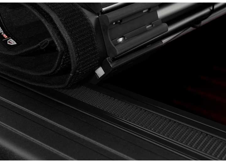 Close-up of the security latch on the end of the rolled cover, in tight macro on a TruXedo Sentry CT hard roll-up tonneau cover
