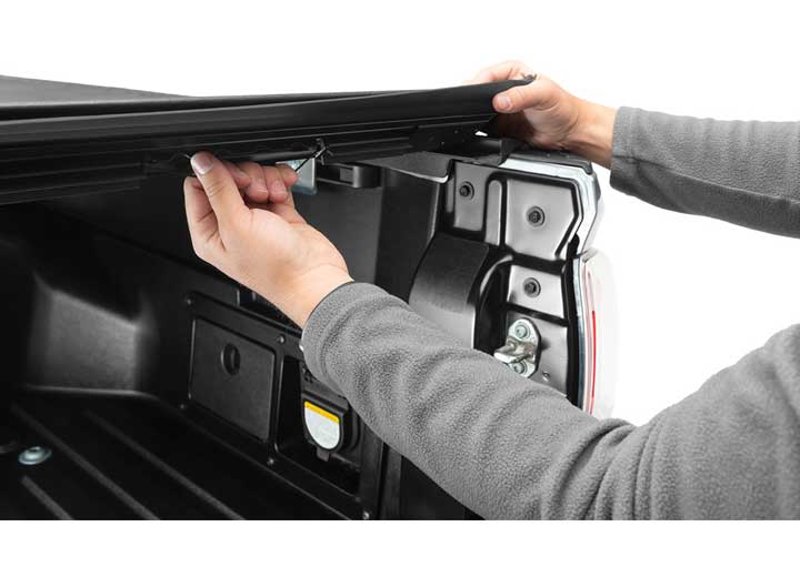 Close-up of the release lever at the rear corner on a TruXedo Sentry hard roll-up tonneau cover
