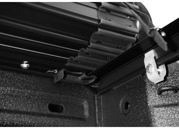 Close-up of the release lever at the rear corner on a TruXedo Sentry hard roll-up tonneau cover