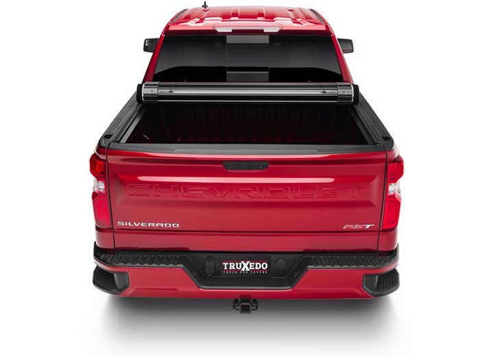 TruXedo Sentry hard roll-up tonneau cover rolled partway open over the bed of a pickup truck, straight rear view