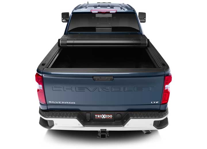 TruXedo Sentry hard roll-up tonneau cover rolled partway open over the bed of a pickup truck, straight rear view