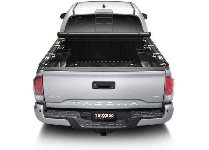 TruXedo TruXport soft roll-up tonneau cover rolled forward to the cab on a 2016-2023 Toyota Tacoma, straight rear view