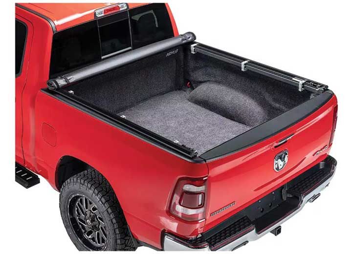 TruXedo TruXport soft roll-up tonneau cover rolled forward to the cab on a 2019-2024 Ram 1500, close rear three-quarter view