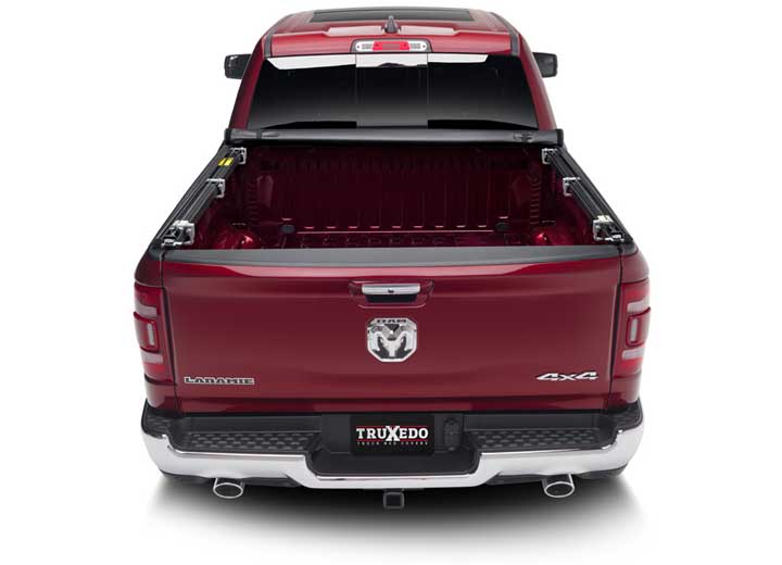 TruXedo TruXport soft roll-up tonneau cover rolled forward to the cab on a 2019-2024 Ram 1500, straight rear view