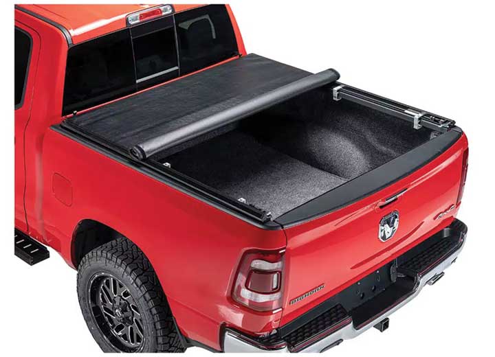 TruXedo TruXport soft roll-up tonneau cover rolled partway open on a 2019-2024 Ram 1500, close rear three-quarter view