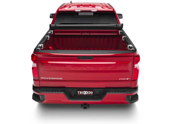 TruXedo TruXport soft roll-up tonneau cover rolled forward to the cab over the bed of a pickup truck, straight rear view
