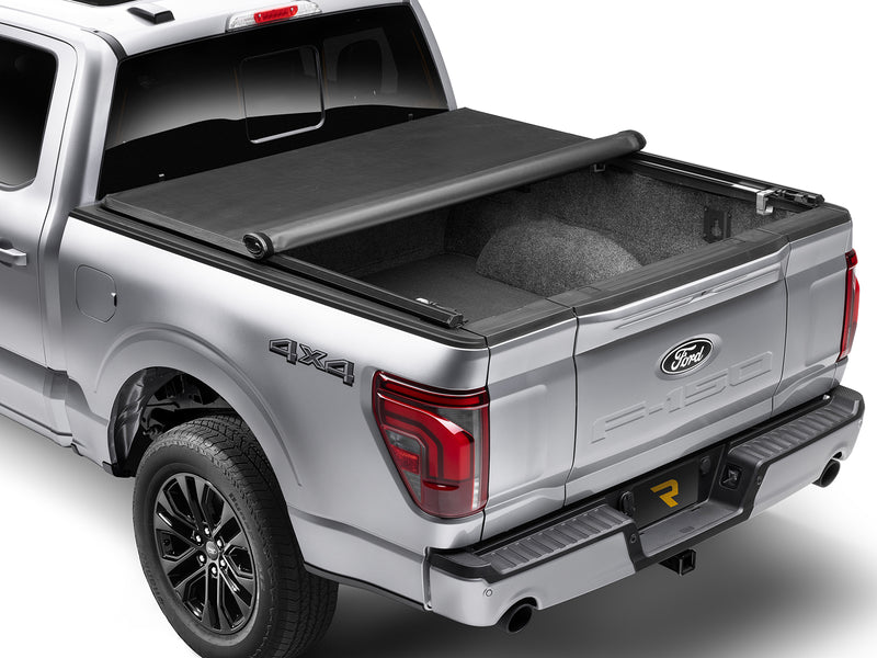 TruXedo TruXport soft roll-up tonneau cover rolled partway open over the bed of a pickup truck, close rear three-quarter view