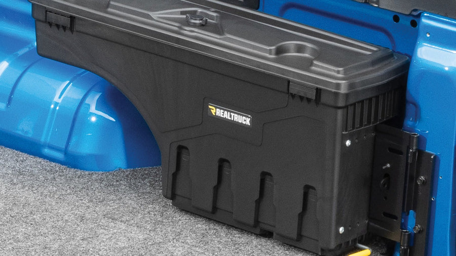 UnderCover SwingCase swing-out truck bed toolbox mounted over the wheel arch inside a pickup bed, lid closed and latched