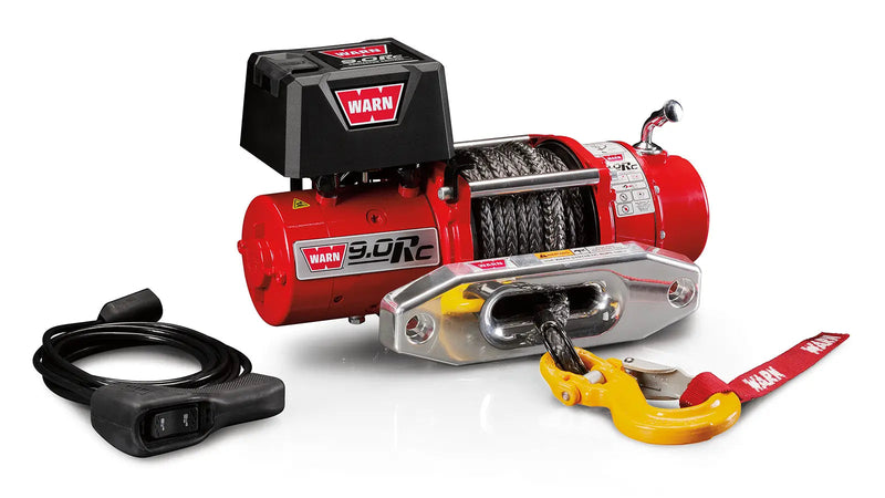 Warn 9.0Rc winch, three-quarter view on white, showing the gloss red body, free-spool clutch lever, synthetic rope, aluminum hawse fairlead, swivel hook and the wired remote switch