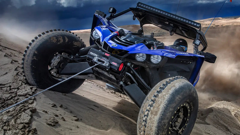 Warn AXON 45RC compact winch mounted on a sport side-by-side in sand dunes, Spydura synthetic rope on the drum