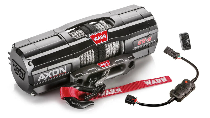 Warn AXON 55-S powersports winch, three-quarter view on white, shown with the rockerbar digital control switch and hub wireless receiver, plus a corded remote socket and wiring harness supplied with it