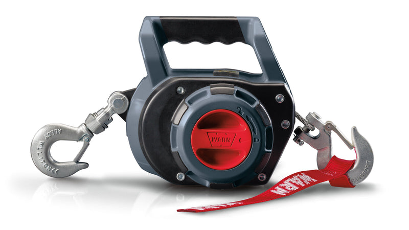Warn Drill Winch in grey and black, three-quarter view on white, showing the moulded carry handle, the red drill drive socket on the side, and a rigging hook at each end with a red Warn strap