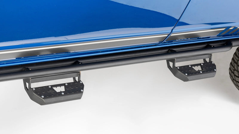 Warn Rock Sliders for 2021-2026 Ford Bronco 4-Door, installed on a blue Ford Bronco, shown with Warn's optional step kit (sold separately)
