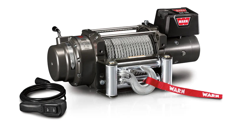 Warn M15 winch, three-quarter view on white, showing the free-spool clutch lever, wire rope on the drum, roller fairlead and the wired remote switch