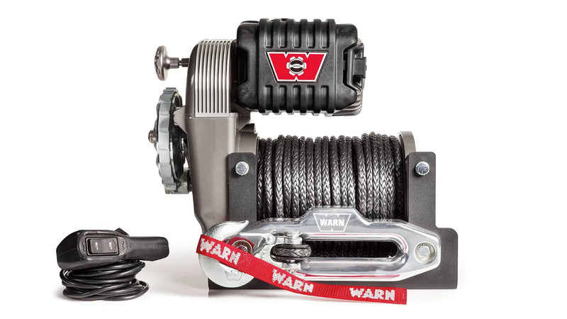 Warn M8274-S winch, front elevation on white, showing the upright frame, black Spydura synthetic rope on the drum, aluminum hawse fairlead and the wired remote