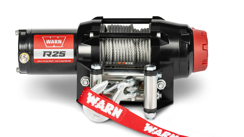 Warn R25 powersports winch, front elevation on white, showing steel wire rope on the drum, the roller fairlead and the hook with its red Warn strap