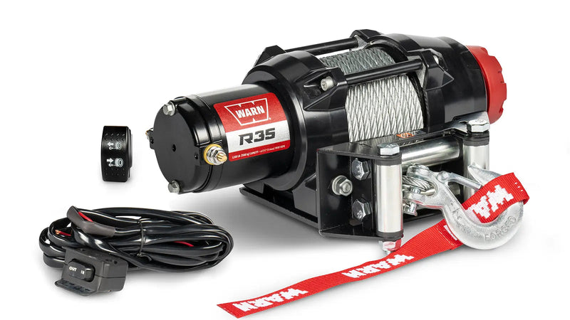 Warn R35 powersports winch, three-quarter view on white, shown with the handlebar-mounted rocker switch and dash-mounted control switch supplied with it