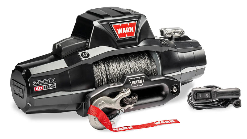 Warn ZEON XD 10-S winch at an angle showing the armored control pack, drum and hawse fairlead, with the corded remote alongside