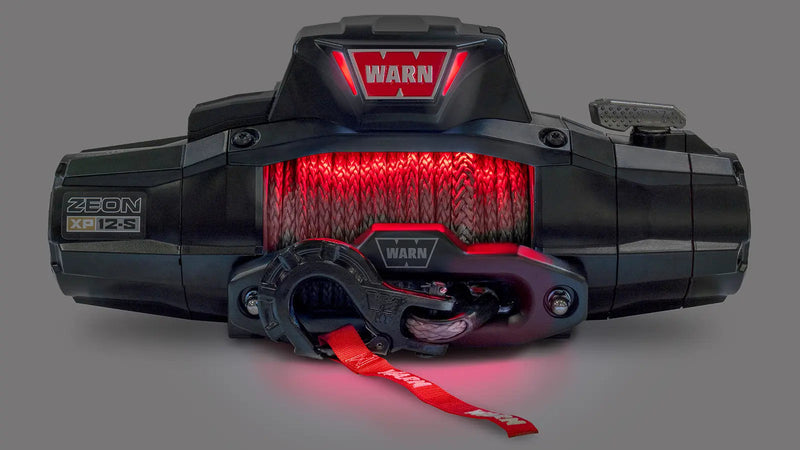 Warn ZEON XP 12-S winch photographed in the dark with its drum and accent lighting glowing red