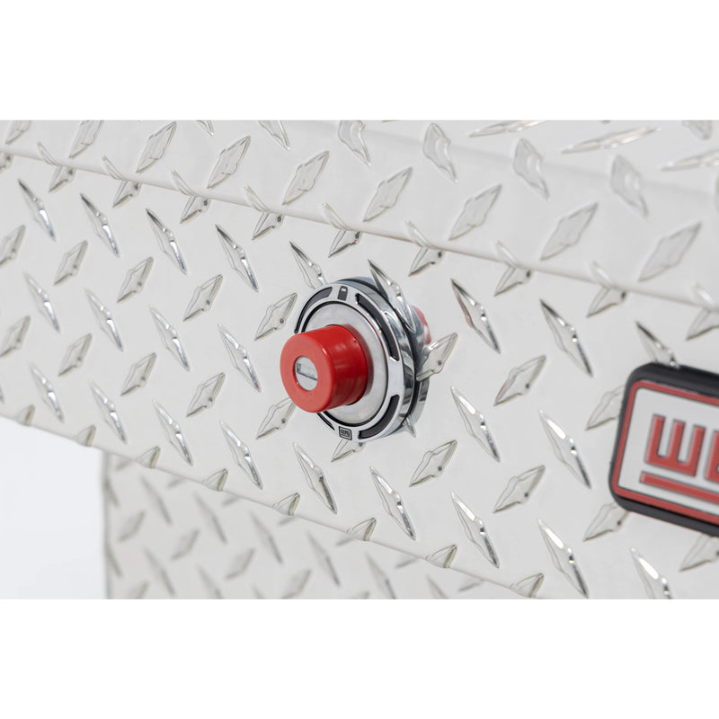 Weather Guard 114-0-04 gull-wing crossover box in bright aluminum diamond plate, close-up of the red push-button lock and Weather Guard badge