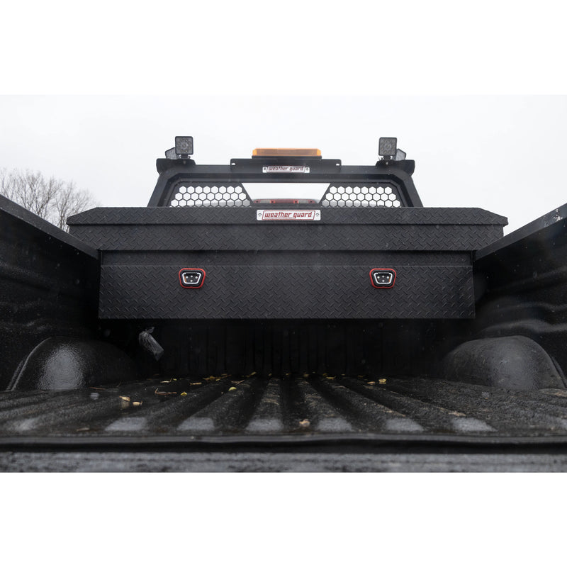 View forward along a truck bed toward the Weather Guard hex headache rack and a mounted crossover box