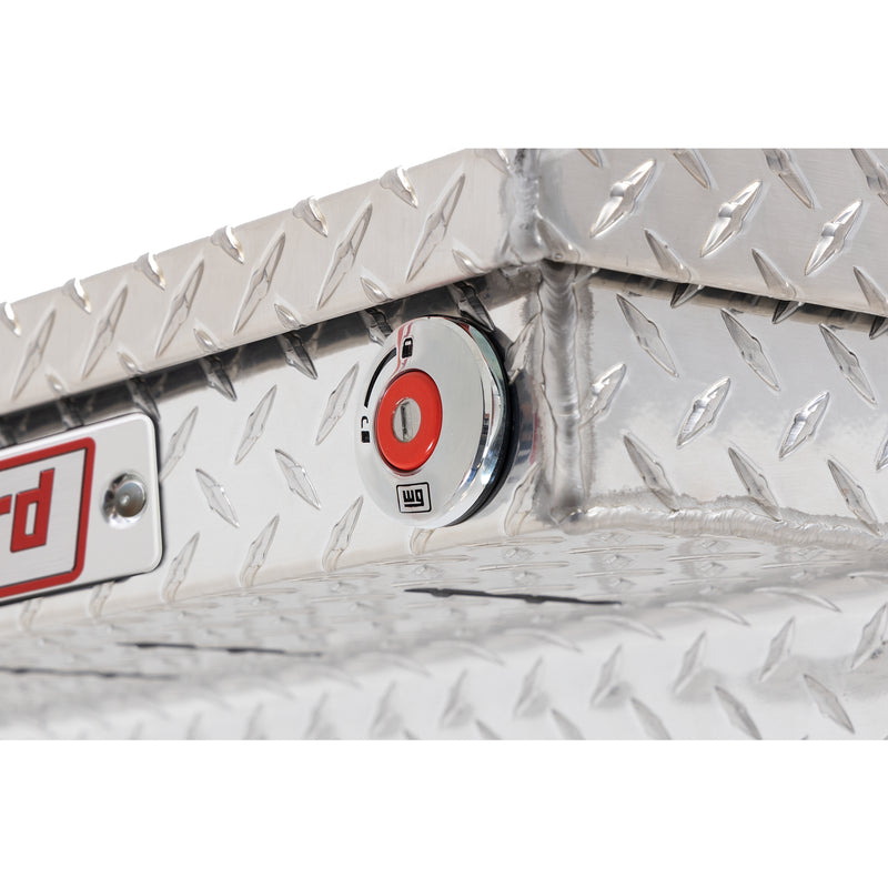 Weather Guard 123-0-04 crossover saddle box in bright aluminum diamond plate, close-up of the red push-button lock and Weather Guard badge