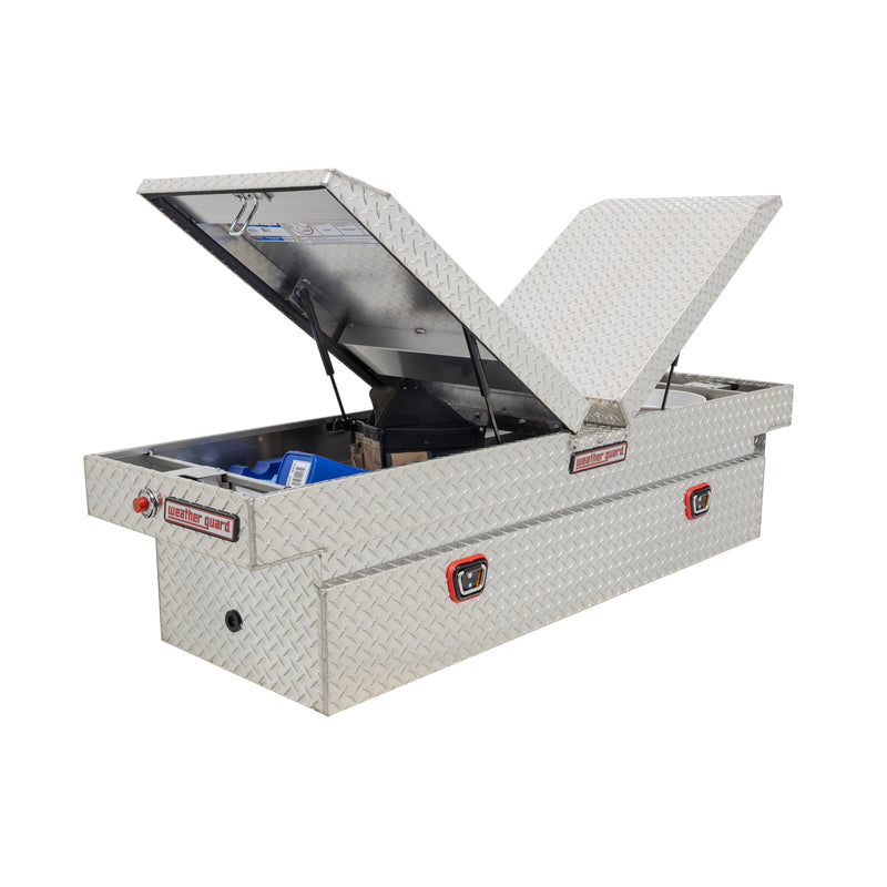Weather Guard 124-0-04 gull-wing crossover box in bright aluminum diamond plate, staged open with hand tools inside to show how the usable space loads