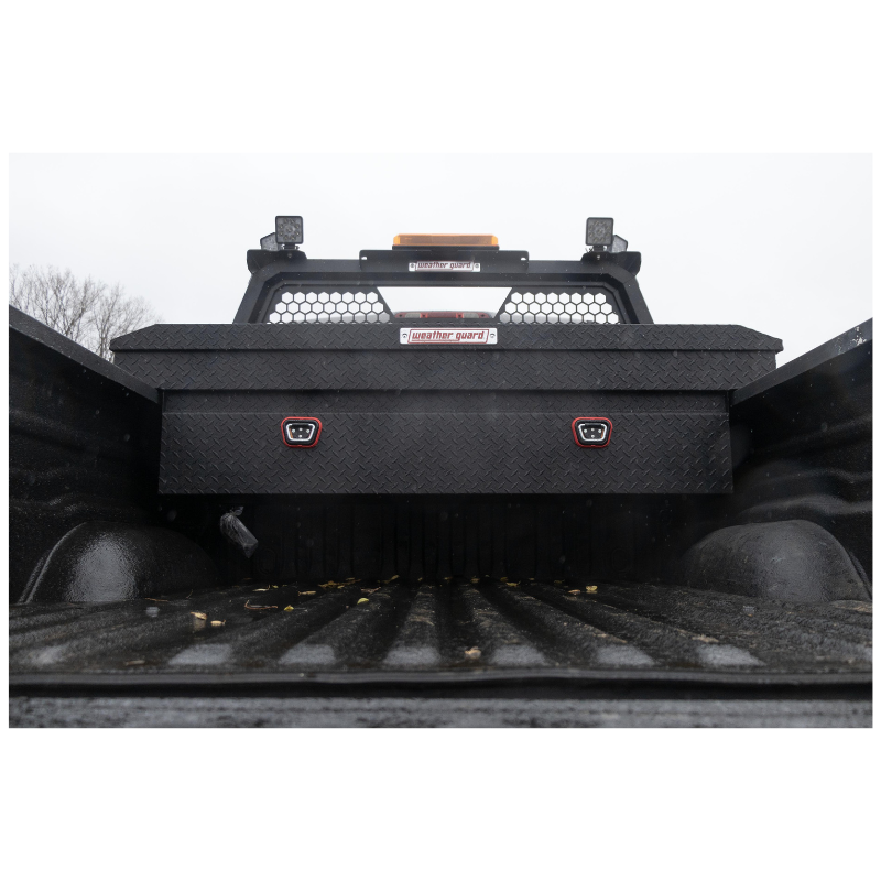 Weather Guard 127-52-04 matte black crossover box mounted across the bed rails behind the cab of a full-size truck, shown with a headache rack