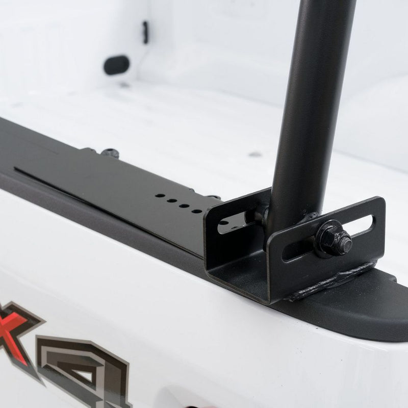Close-up of the Weather Guard truck rack no-drill stake-pocket mounting bracket clamped to a white pickup bed rail