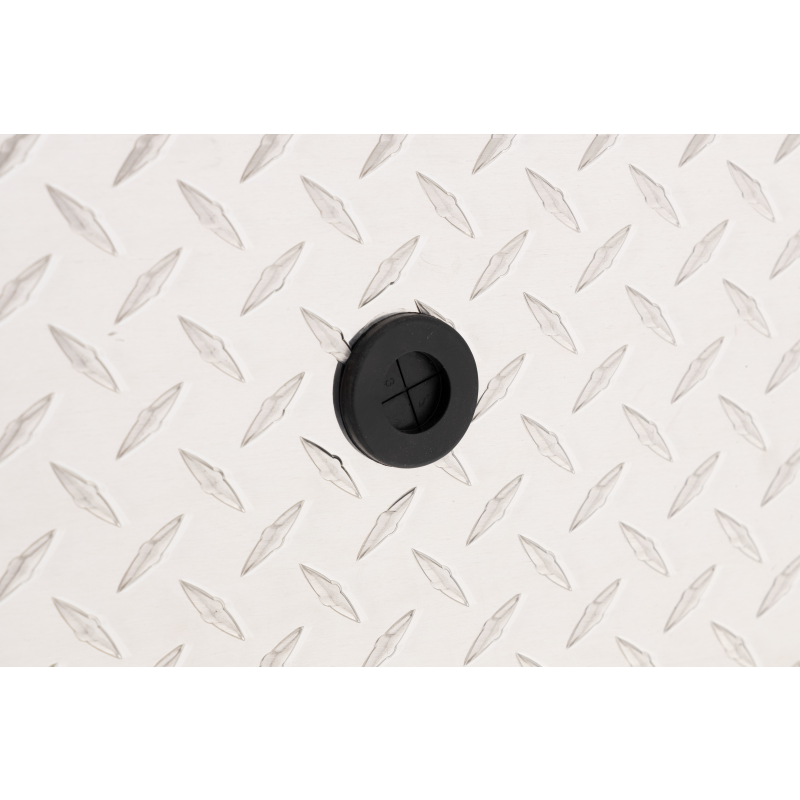 Close-up of the black rubber drain plug set into the bright aluminum diamond-plate floor of the Weather Guard 164-0-04 Lo-Side box
