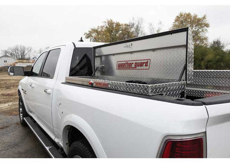 Weather Guard 178-0-04 low-profile Lo-Side box in bright aluminum diamond plate, mounted along the bed rail of a white Ram pickup with the lid open