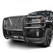 Westin HDX grille guard in polished stainless steel with punch plate mesh mounted on a black pickup truck against a plain white studio background
