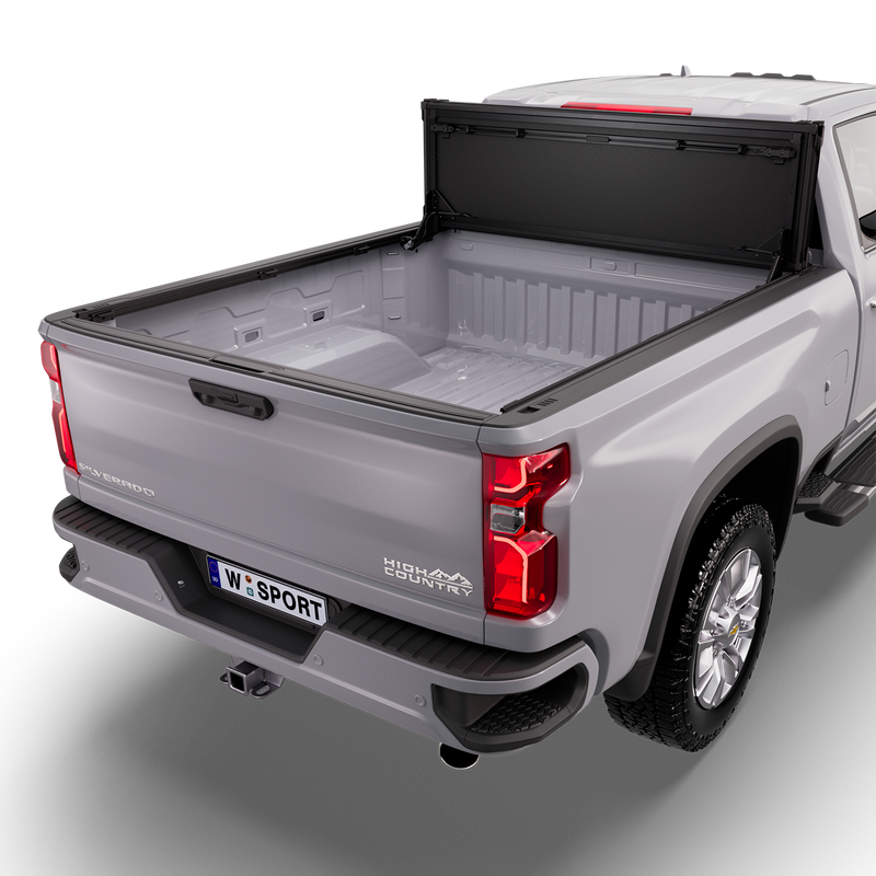 Worksport NEXUS hard folding tonneau cover on a pickup: studio render of a silver Chevrolet Silverado High Country from the rear quarter with a black NEXUS hard folding tonneau cover flipped up vertical against the cab, bed fully open