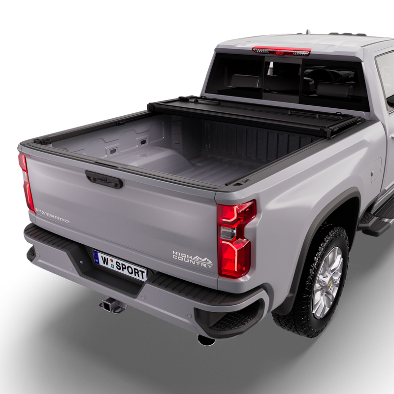 Worksport NEXUS hard folding tonneau cover on a pickup: studio render of a silver Chevrolet Silverado High Country from the rear quarter with a black NEXUS hard folding tonneau cover folded twice and stacked at the cab