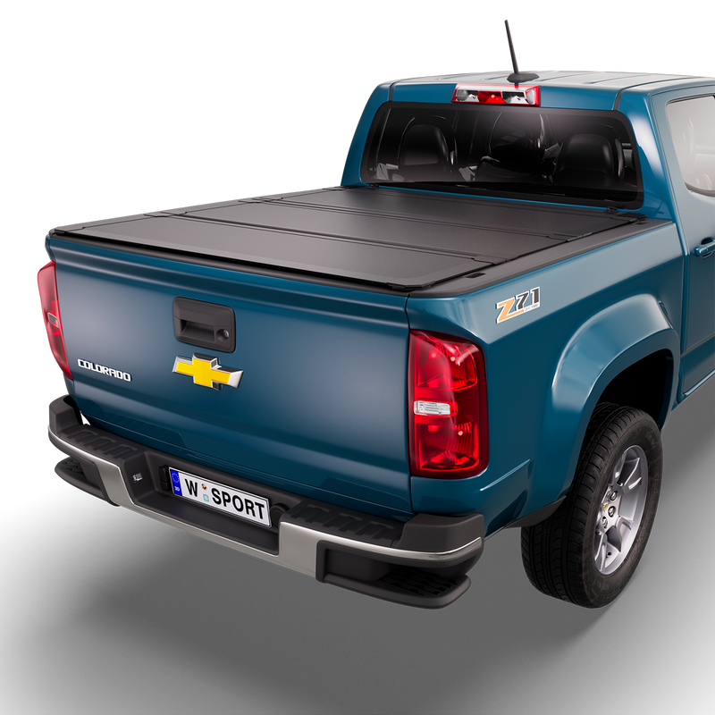 Worksport NEXUS hard folding tonneau cover on a pickup: 3D studio render of a blue Chevrolet Colorado from the rear quarter with a black NEXUS hard folding tonneau cover closed, all three panels flat over the bed