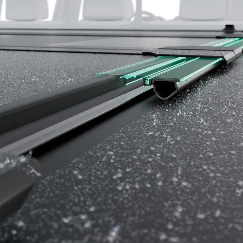 Close-up of the Worksport NEXUS hard folding tonneau cover: wet close-up render of a NEXUS panel edge resting on the rail, with the seal highlighted in green