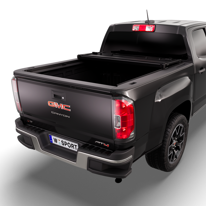 Worksport NEXUS hard folding tonneau cover on a pickup: 3D studio render of a black GMC Canyon from the rear quarter with a black NEXUS hard folding tonneau cover folded twice into a stack at the cab end, most of the bed open