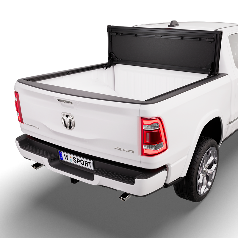 Worksport NEXUS hard folding tonneau cover on a pickup: 3D studio render of a white Ram 1500 from the rear quarter with a black NEXUS hard folding tonneau cover folded stack flipped up vertical against the cab, full bed open